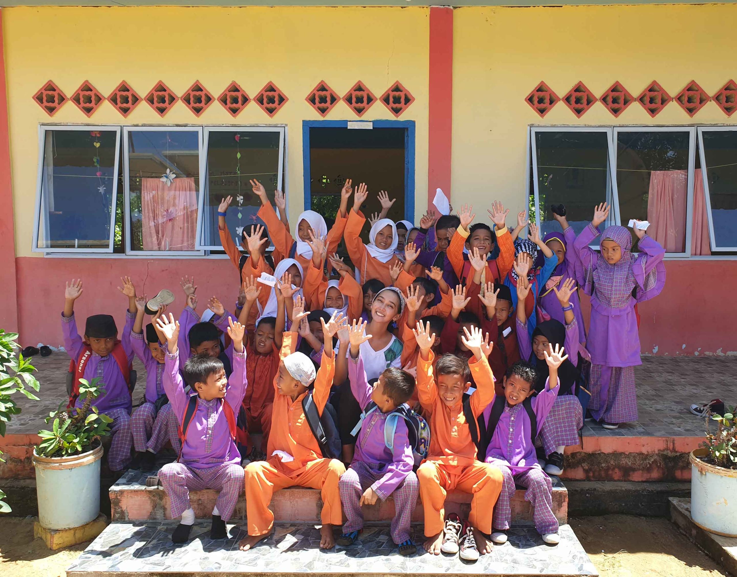 happy_indonesian_village_kids_in_uniform_posing_with_anambas_foundation_staff_in_school